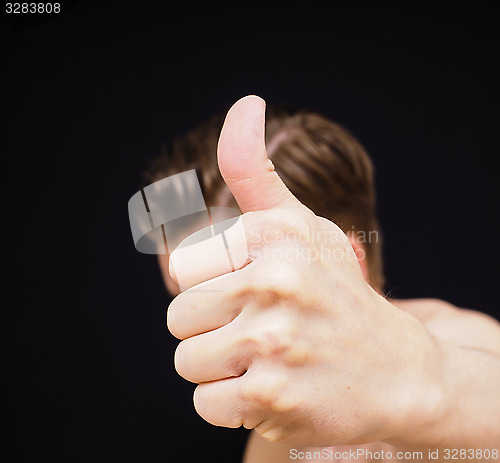 Image of Caucasian male showing thumbs up covering face isolated on black