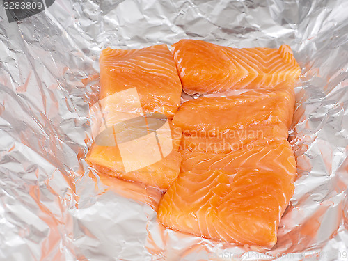 Image of Closeup of unseasoned salmon pieces in aluminum foil