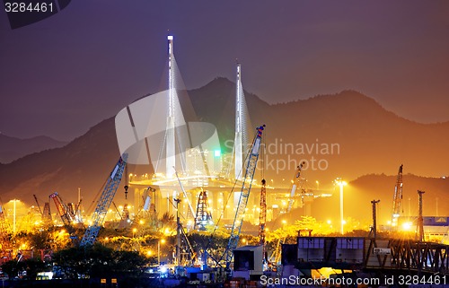 Image of Container Cargo freight ship with working crane bridge