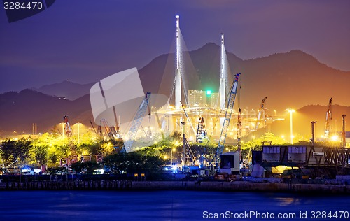 Image of Container Cargo freight ship with working crane bridge