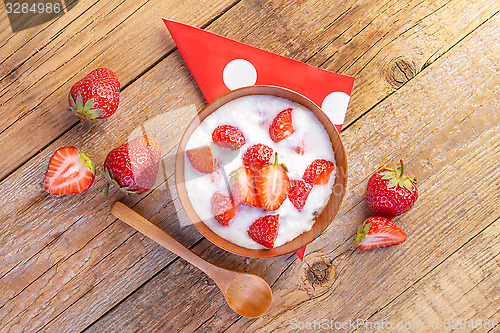 Image of fresh organic greek yogurt with strawberries on wooden