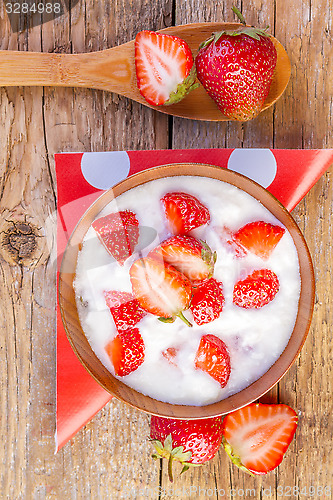Image of fresh organic greek yogurt with strawberries on wooden