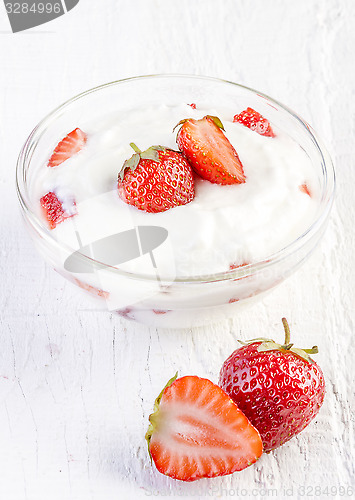 Image of fresh organic yogurt with strawberries on wooden