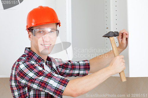 Image of repairman in a helmet with a hammer