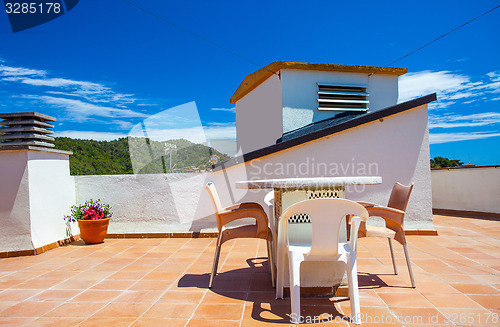 Image of table and chairs on the roof under the open sky