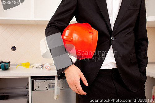 Image of businessman holding red helmet