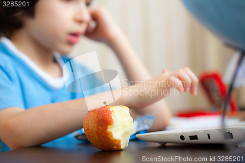 Image of bitten apple and a boy with computer