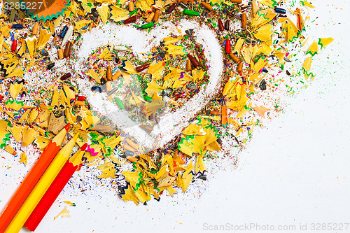 Image of heart, multicolored pencils and varicolored wooden shavings