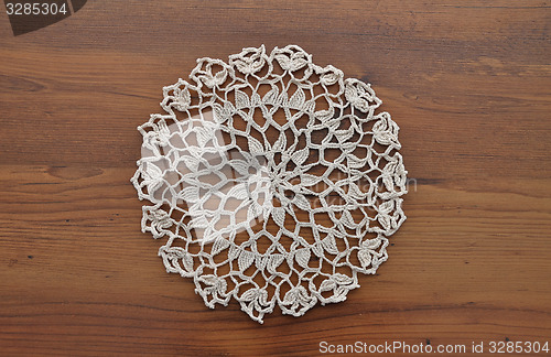 Image of Lace doily on dark wood