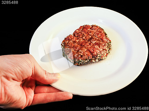 Image of Serving raw burger on white plate isolated on black