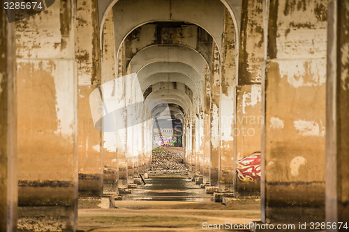 Image of standing under old bridge over the river