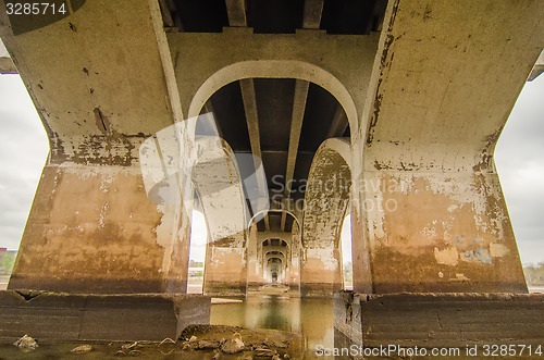 Image of standing under old bridge over the river