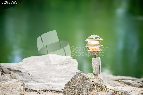 Image of mood lighting light fixture on rocks by the water