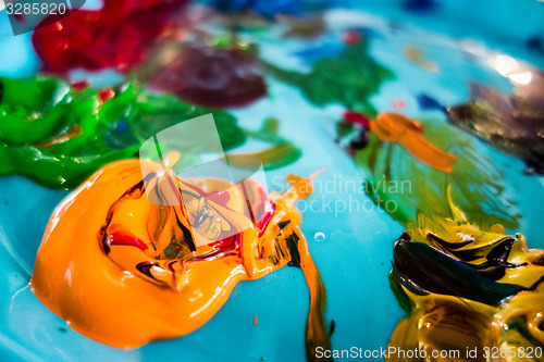 Image of mixed oil paints on pallet with various colors