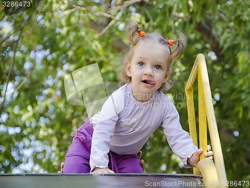 Image of The little girl crawling up a hill 