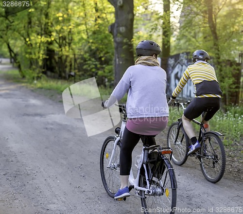 Image of Young women on bikes in park