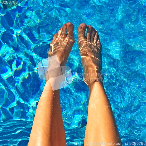 Image of Female feet in blue water