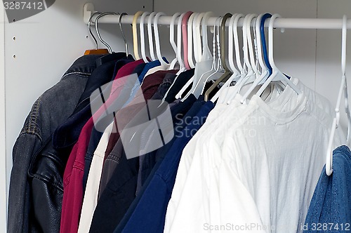 Image of jackets and shirts inside closet
