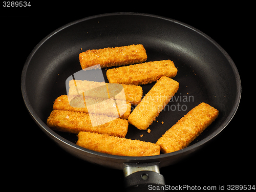 Image of Crumbed fish fingers in fry pan, isolated on black