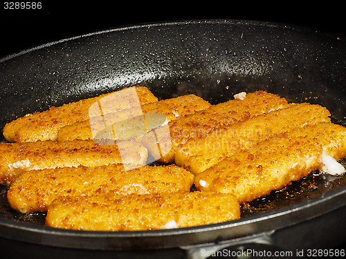 Image of Closeup of crispy breaded fish fingers in hot fry pan