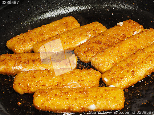 Image of Closeup of crispy breaded fish fingers in hot fry pan