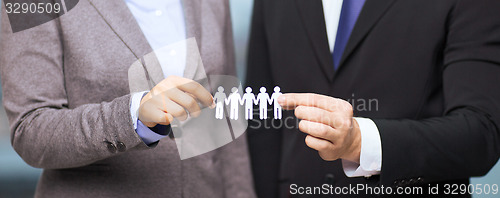 Image of businessman and businesswoman holding paper team