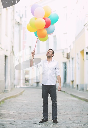 Image of man with colorful balloons in the city