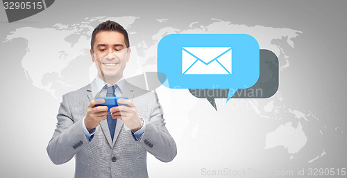 Image of happy businessman texting message on smartphone