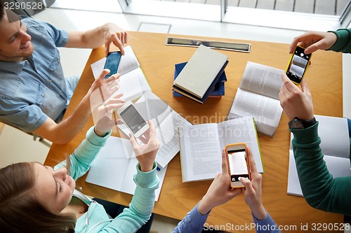 Image of students with smartphones making cheat sheets