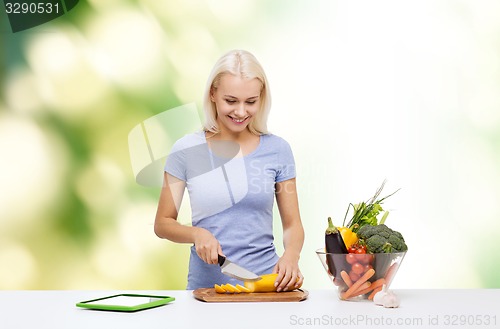 Image of smiling young woman cooking vegetables