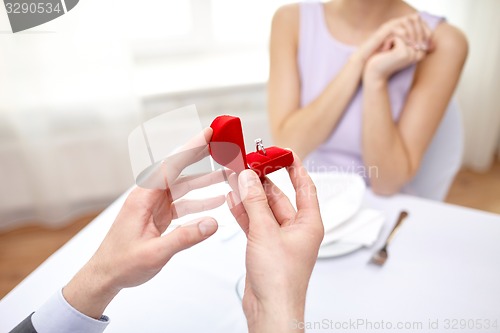 Image of excited young woman and boyfriend giving her ring