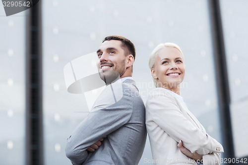 Image of smiling businessmen standing over office building