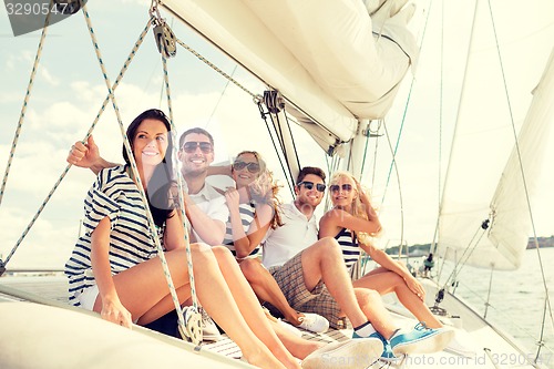 Image of smiling friends sitting on yacht deck