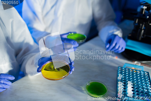 Image of close up of scientists with test samples in lab