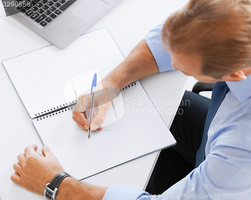 Image of businessman writing in notebook