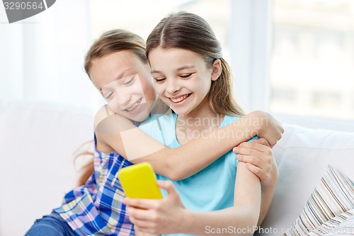 Image of happy girls with smartphone taking selfie at home