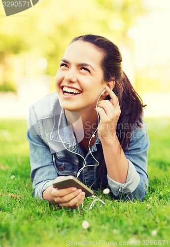 Image of laughing young girl with smartphone and earphones