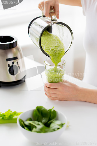 Image of close up of woman with blender jar and green shake