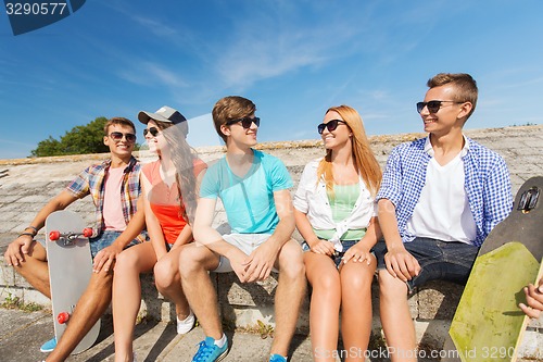 Image of group of smiling friends sitting on city street