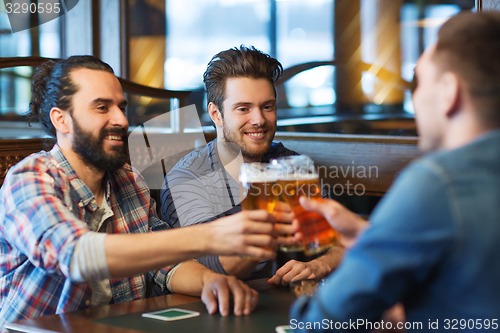 Image of happy male friends drinking beer at bar or pub