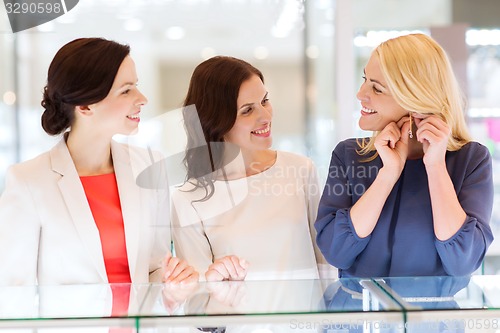 Image of happy women choosing earrings at jewelry store