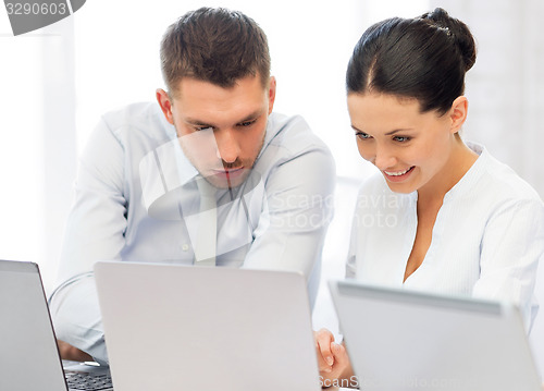 Image of group of people working with laptops in office