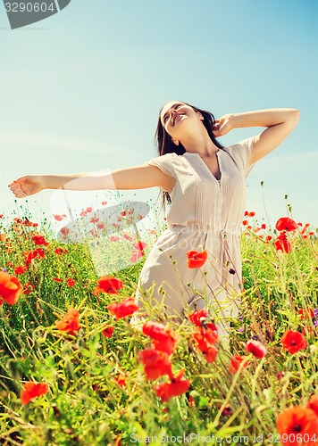 Image of smiling young woman on poppy field