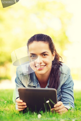 Image of smiling young girl tablet pc lying on grass