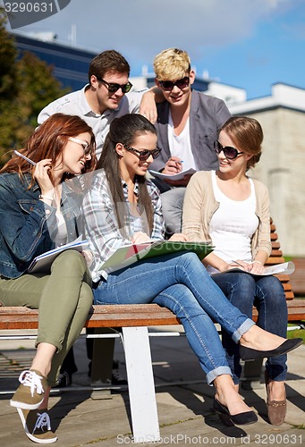 Image of group of happy students with notebooks at campus