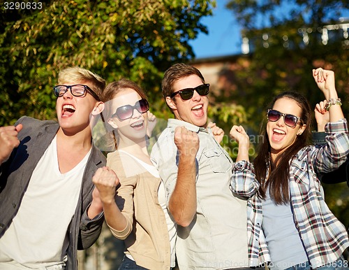 Image of group of happy friends showing triumph gesture