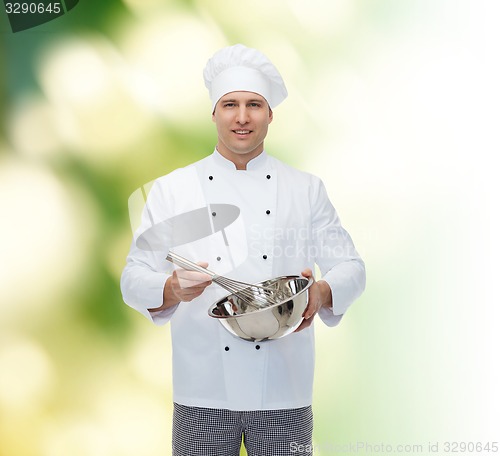 Image of happy male chef cook whipping something with whisk