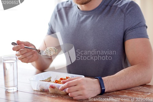 Image of close up of man with fork and water eating food