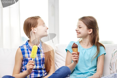 Image of happy little girls eating ice-cream at home