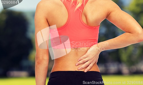 Image of close up of sporty woman touching her back